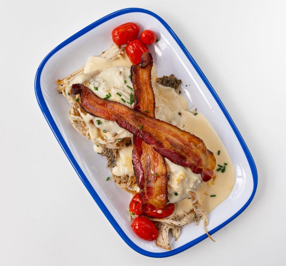 Biscuit Belly's take on the Hot Brown starts with an open-faced scratch-made biscuit, covered in a smoked gouda mornay gravy, and topped with shredded turkey, bacon, and roasted tomatoes, giving you the ultimate Kentucky brunch experience.