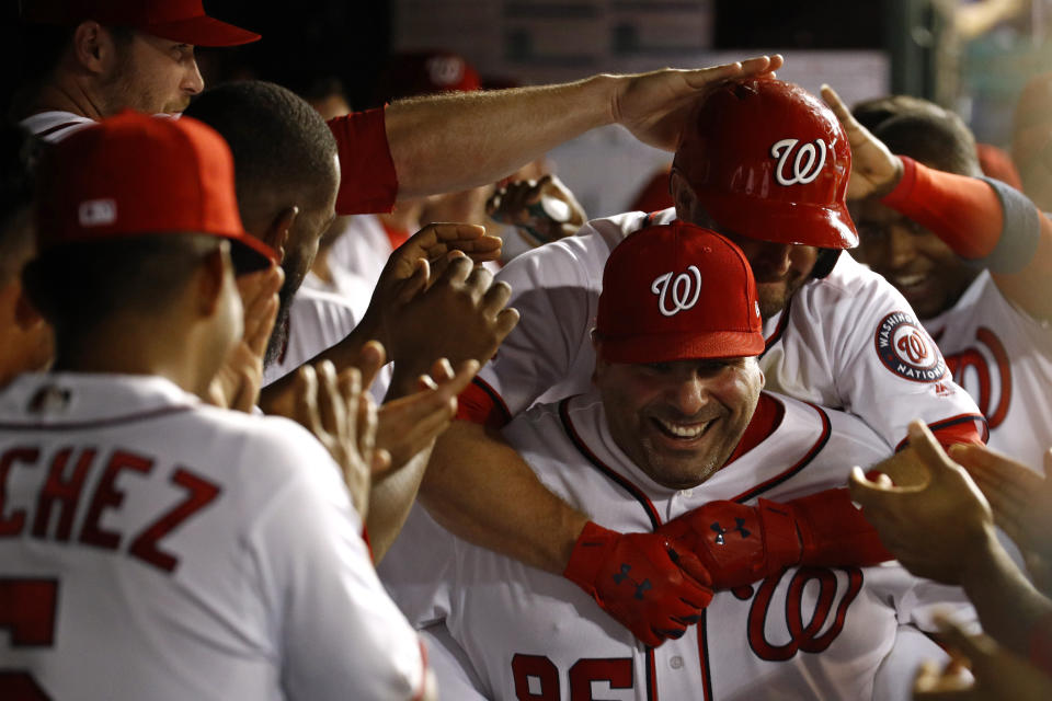 Washington Nationals batting practice pitcher Ali Modami, bottom right, carries Brian Dozier through the dugout after Dozier hit a solo home run during a game in September. (AP)