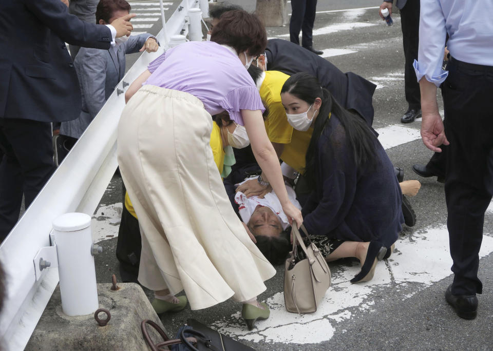 El ex primer ministro japonés Shinzo Abe, al centro, yace en el piso tras ser baleado el viernes 8 de julio de 2022, en Nara, en el oeste de Japón. Abe presentaba falla cardiaca, indicó la televisora NHK. (Kyodo News vía AP)