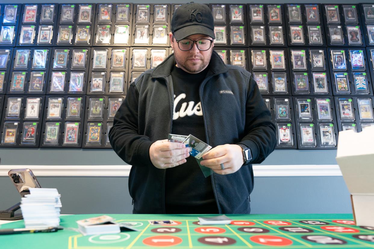 Matthew Waits, owner of O's Hobby Shop, carefully places an NFL football card of Josh Allen, quarterback for the Buffalo Bills, into a protective sleeve as he files a batch of cards Wednesday at his new shop at 1927 S.W. Gage Blvd.