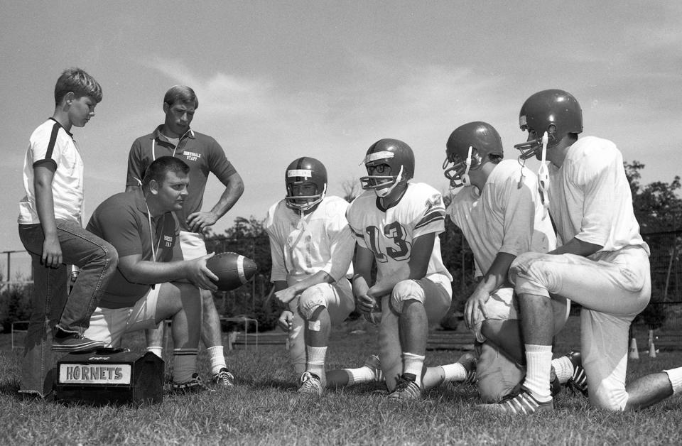 Honesdale'e very first head football coach, Allen "Butch" Keller confers with his star players during the 1968-69 varsity campaign.