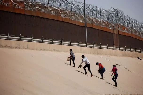 PHOTO: Asylum-seeking migrants walk near the border wall after crossing the Rio Bravo, in El Paso, Texas, as seen from Ciudad Juarez, Mexico, April 6, 2022. (Jose Luis Gonzalez/Reuters, FILE)