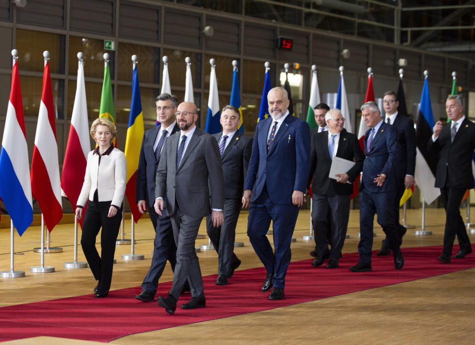 FILE - European Council President Charles Michel, right front, and European Commission President Ursula von der Leyen, front left, walk with leaders of the Western Balkans prior to a group photo in Brussels on Feb. 16, 2020. The European Union is in the midst of yet another goodwill trip through the neighboring Western Balkans in its drive to drum up support for the bloc and to make sure that the historical tinderbox is not about to pick the side of hostile Russia or strategic rival China in the geopolitical fight. (AP Photo/Virginia Mayo, File)