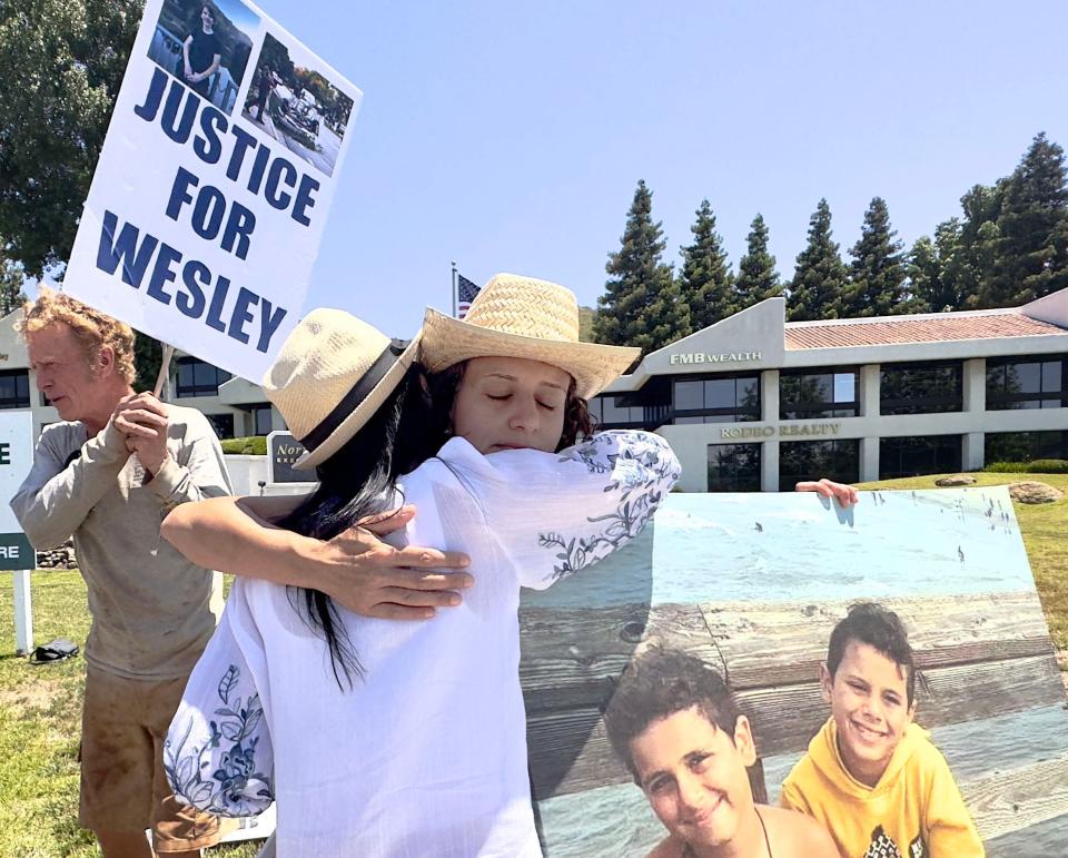 Organizer Julie Cohen gives Miriam Guirguis, aunt of Mark and Jacob Iskander, a hug at the "stand up for victims" event at the corner of Westlake and Thousand Oaks boulevards on June 30. The boys died while walking in a crosswalk with their family in Westlake Village in September 2020.
