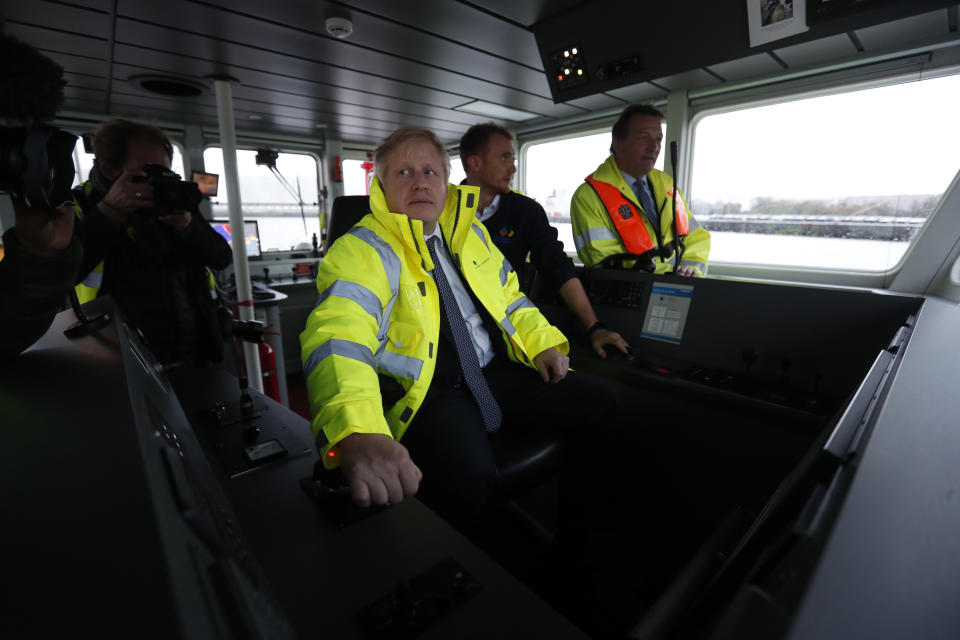 Britain's Prime Minister Boris Johnson steers a tug boat during a General Election campaign stop in the port of Bristol, England, Thursday, Nov. 14, 2019. Britain goes to the polls on Dec. 12. (AP Photo/Frank Augstein, Pool)