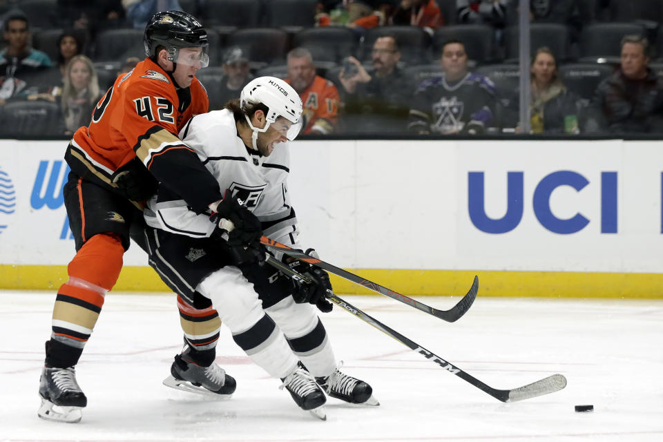 Los Angeles Kings left wing Kyle Clifford, right, is stopped by Anaheim Ducks defenseman Josh Manson, left, during the first period of an NHL hockey game in Anaheim, Calif., Thursday, Dec. 12, 2019. (AP Photo/Alex Gallardo)