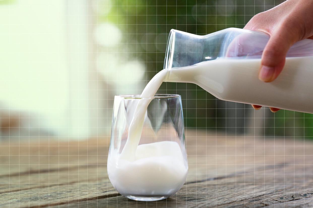The milk is poured into a ceramic jug into a glass on a natural background