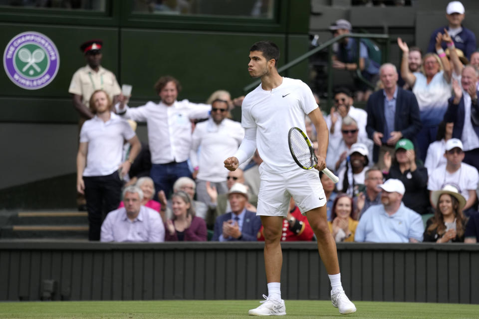 Spain's Carlos Alcaraz celebrates winning the third set against Italy's Jannik Sinner during a men's fourth round singles match on day seven of the Wimbledon tennis championships in London, Sunday, July 3, 2022.(AP Photo/Kirsty Wigglesworth)