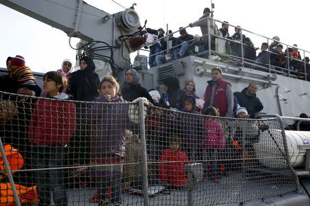 Refugees and migrants are seen aboard the Ayios Efstratios Coast Guard vessel following a rescue operation, at the port of the Greek island of Lesbos, February 8, 2016. REUTERS/Giorgos Moutafis