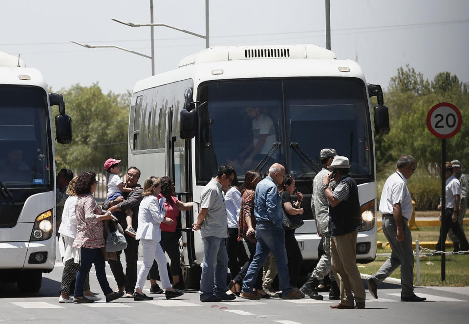 Relatives of passengers of a missing military plane arrive by bus to the Cerrillos airbase in Santiago, Chile, Tuesday, Dec. 10, 2019. Chile's air force said it lost radio contact with a C-130 Hercules transport plane carrying 38 people on a flight to the country's base in Antarctica, and authorities are indicating they are not optimistic about the aircraft's fate. (AP Photo/Luis Hidalgo)