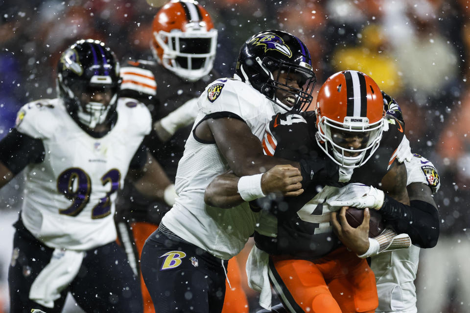 Baltimore Ravens linebacker Roquan Smith, center, tackles Cleveland Browns quarterback Deshaun Watson (4) during the second half of an NFL football game, Saturday, Dec. 17, 2022, in Cleveland. (AP Photo/Ron Schwane)