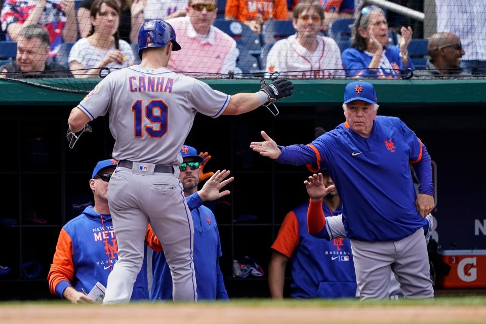 New York Mets' Mark Canha celebrates scoring with manager Buck Showalter, right, during the fourth inning of a baseball game against the Washington Nationals at Nationals Park, Thursday, May 12, 2022, in Washington.