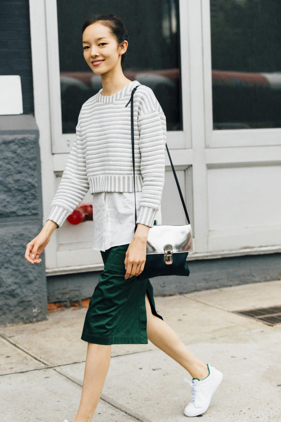 Sweater layered over shirt + split side skirt + white sneakers, with details that match top / skirt