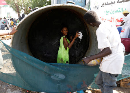 A Sudanese volunteer washes a huge cauldron used for cooking food for protesters outside the defence ministry compound in Khartoum, Sudan, April 24, 2019. REUTERS/Umit Bektas