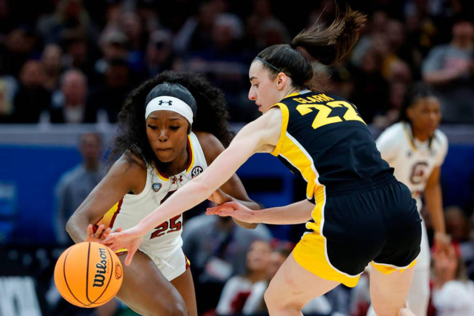 South Carolina's Raven Johnson (25) swipes the ball from Iowa's Caitlin Clark (22) during the National Championship game