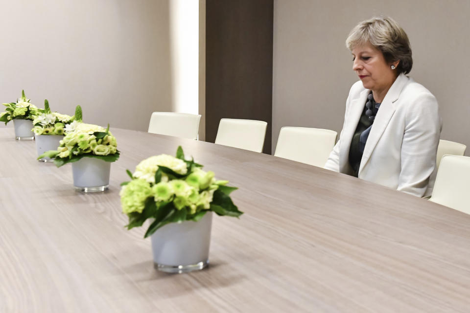 FILE - In this Friday, Oct. 20, 2017 file photo, British Prime Minister Theresa May waits for the arrival of European Council President Donald Tusk prior to a bilateral meeting with European Council President Donald Tusk during an EU summit in Brussels. After months of stalled talks, false starts and setbacks, negotiators from Britain and the European Union struck a proposed divorce deal Tuesday Nov. 13, 2018, to provide for the U.K.'s smooth exit from the bloc. But the agreement faces major political hurdles starting Wednesday, when British Prime Minister Theresa May will try to win the approval of her divided Cabinet for a deal many ministers view with skepticism. (AP Photo/Geert Vanden Wijngaert, Pool)