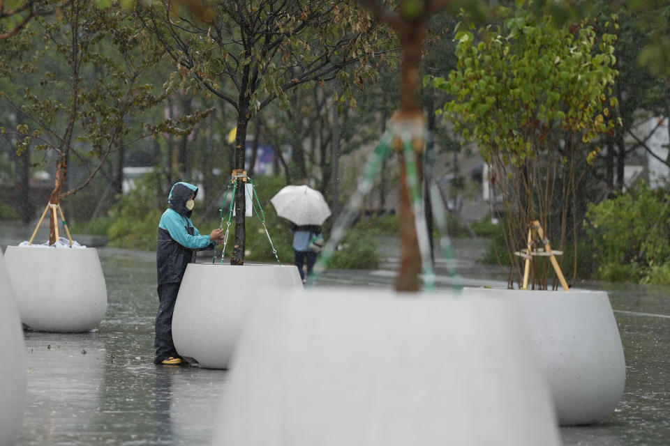 A worker checks facilities at a square as Typhoon Hinnamnor travels toward the Korean Peninsula in Seoul, South Korea, Monday, Sept. 5, 2022. Hundreds of flights were grounded and more than 200 people evacuated in South Korea on Monday as Typhoon Hinnamnor approached the country's southern region with heavy rains and winds of up to 290 kilometers (180 miles) per hour, the strongest storm in decades. (AP Photo/Lee Jin-man)