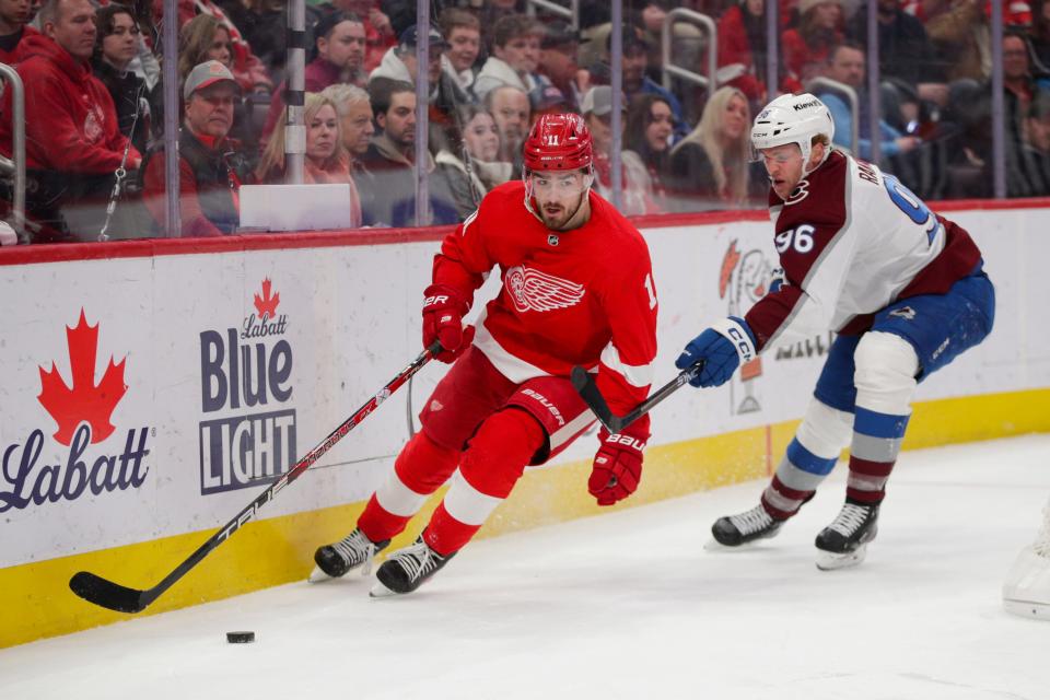 Detroit Red Wings right wing Filip Zadina (11) handles the puck under pressure from Colorado Avalanche right wing Mikko Rantanen (96) during the third period at Little Caesars Arena in Detroit on Saturday, March 18, 2023.