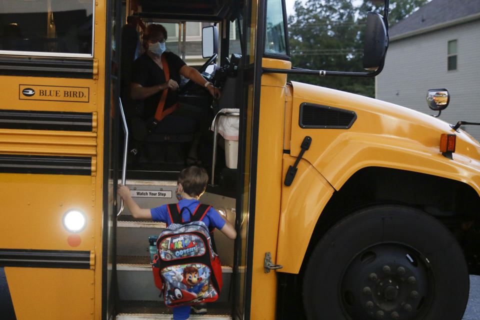 Paul Adamus, 7, climbs the stairs of a bus before the fist day of school on Monday, Aug. 3, 2020, in Dallas, Ga.  (AP Photo/Brynn Anderson) (Photo: ASSOCIATED PRESS)