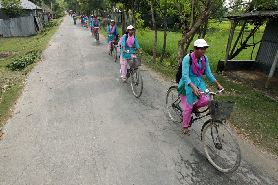 In this Sept. 30, 2012 photo, "Info Ladies" pedal their way to Saghata, a remote impoverished farming village in Gaibandha district, 190 kilometers (120 miles) north of Dhaka, Bangladesh. Dozens of “Info Ladies” bike into remote Bangladeshi villages with laptops and Internet connections, helping tens of thousands of people _ especially women - get everything from government services to chats with distant loved ones. They’ve expanded access to vital computer services in a country where only 5 million of 152 million people have Internet access. (AP Photo/A.M. Ahad)