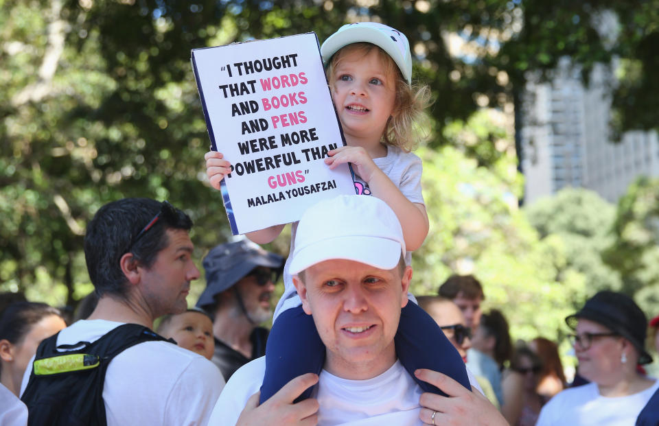 Leila Williams displays a banner as she sits on her fathers shoulders in Hyde Park on January 21, 2017 in Sydney, Australia.&nbsp;