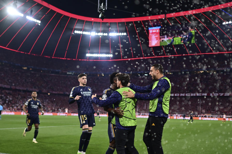 Real Madrid's Vinicius Junior, centre, celebrates with his teammates after scoring his side's second goal on a penalty kick during the Champions League semifinal first leg soccer match between Bayern Munich and Real Madrid at the Allianz Arena in Munich, Germany, Tuesday, April 30, 2024. (AP Photo/Christian Bruna)