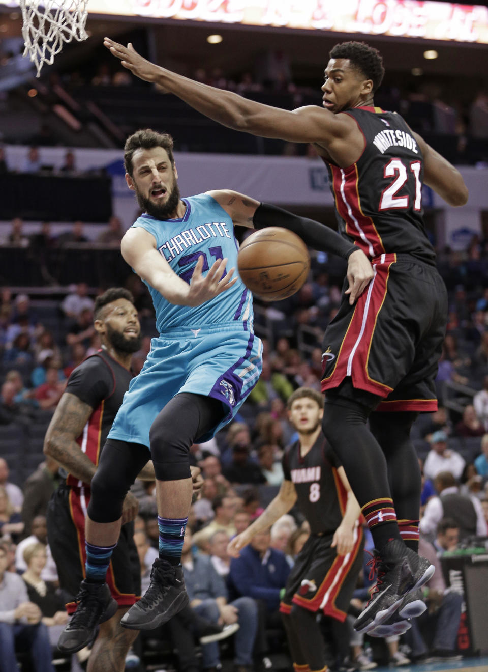 Charlotte Hornets' Marco Belinelli, left, passes the ball around Miami Heat's Hassan Whiteside during the first half of an NBA basketball game in Charlotte, N.C., Wednesday, April 5, 2017. (AP Photo/Chuck Burton)