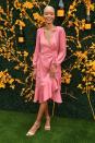 <p>Wearing a pink wrap dress.</p>