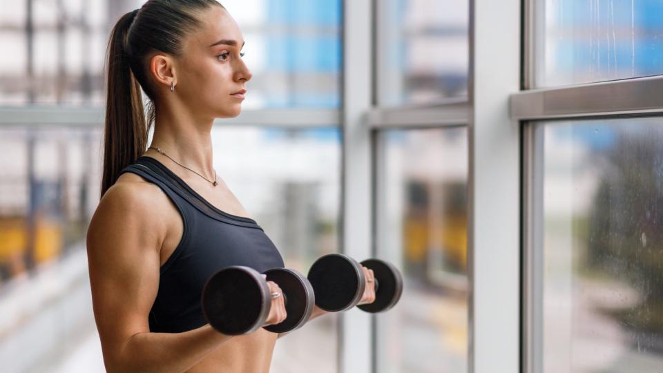 woman doing bicep curls with dumbbells