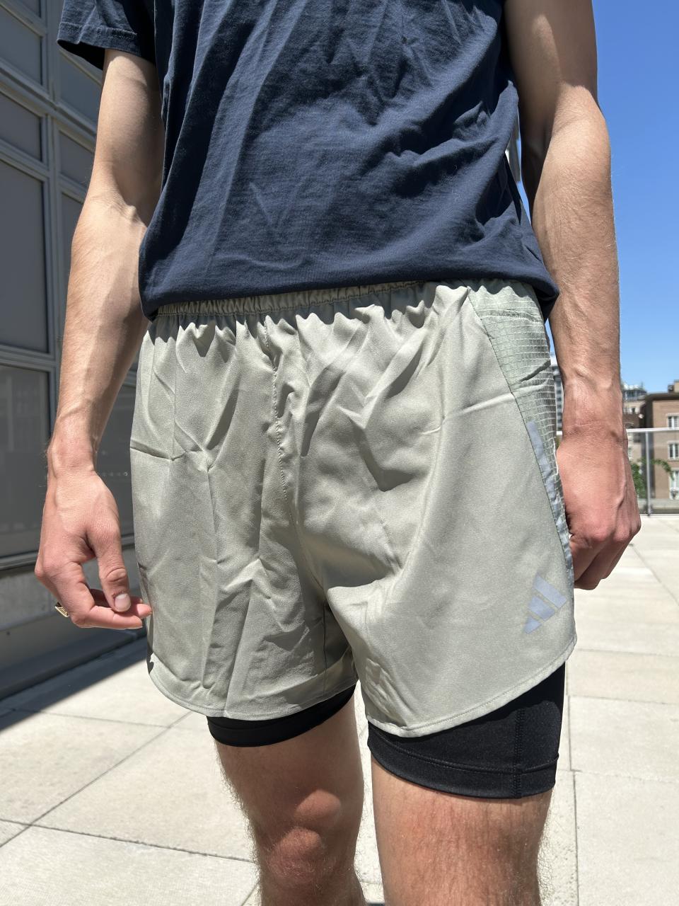 man wearing navy t-shirt, light green athletic shorts