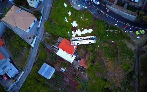 A video grab obtained from drone footage shows the wreckage of a tourist bus that crashed in Canico, on the Portuguese island of Madeira - Credit: AFP