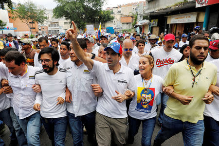 Lawmakers walk together with Venezuelan opposition leader and Governor of Miranda state Henrique Capriles (3rd R) and Lilian Tintori (2nd L) wife of jailed opposition leader Leopoldo Lopez, as they take part in a rally to honour victims of violence during a protest against Venezuela's President Nicolas Maduro's government in Caracas, Venezuela, April 22, 2017. REUTERS/Carlos Garcia Rawlins