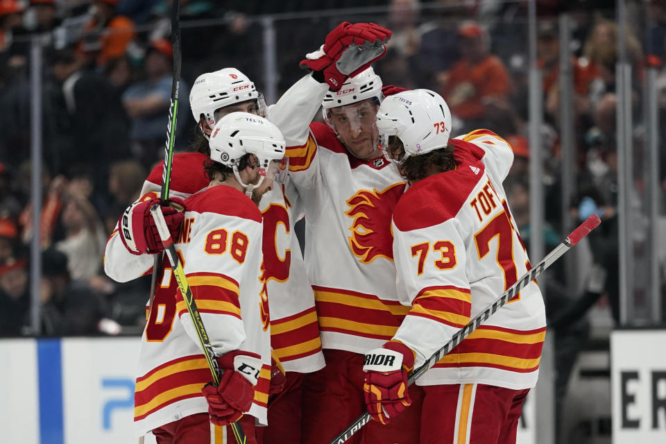 Calgary Flames defenseman Michael Stone, center, celebrates with teammates after scoring during the third period of an NHL hockey game against the Anaheim Ducks in Anaheim, Calif., Wednesday, April 6, 2022. (AP Photo/Ashley Landis)