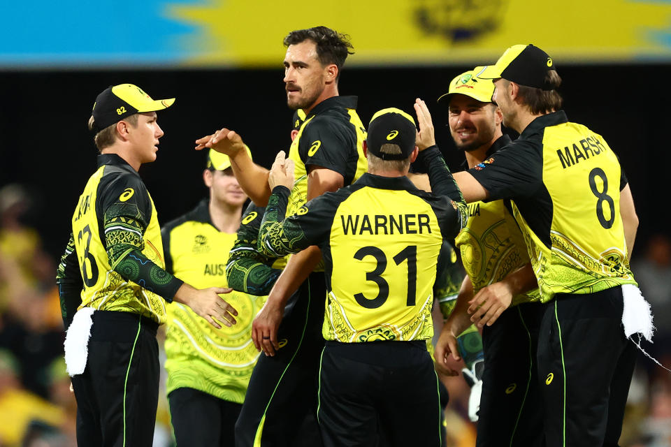 Mitchell Starc (pictured middle) celebrates with his teammates.