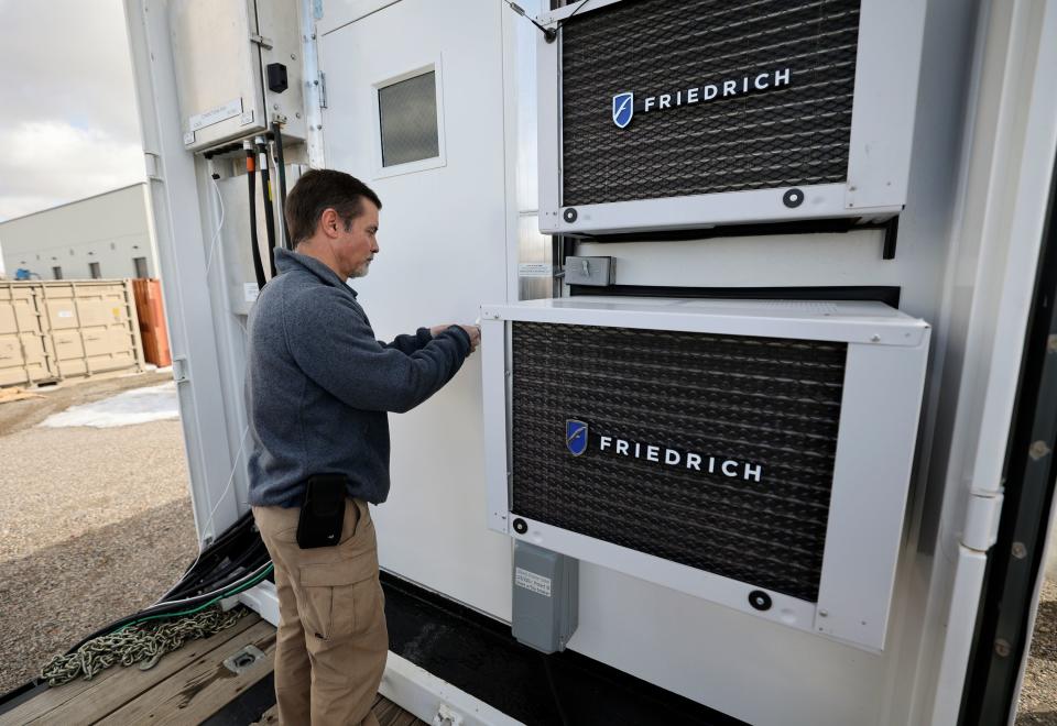 Kurt Myers, Idaho National Laboratory distributed energy and grid systems integration group lead, unlocks a portable shipping container that houses batteries to store energy from solar panels, as part of a microgrid, outside of the INL Energy Systems Laboratory in Idaho Falls, Idaho, on Wednesday, April 5, 2023. | Kristin Murphy, Deseret News