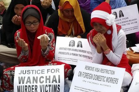 Indonesian women pray during a memorial for two murder victims in Hong Kong November 9, 2014. REUTERS/Venus Wu/Files