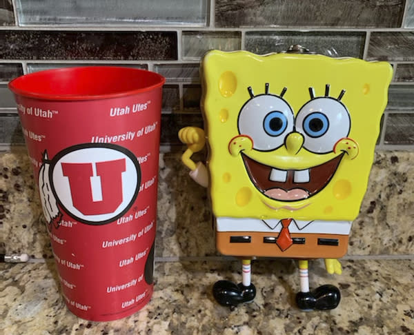 In this photo provided by Utah sports writer Andy Larsen are a childhood piggybank, right, and a plastic cup on Tuesday, Nov. 24, 2020, in Salt Lake City. Larsen's spontaneous tweet looking for someone in need to whom he could give the $185 he had in the two items quickly snowballed into tens of thousands of dollars in donations from strangers, as well as messages from people who could use the help. (Andy Larsen via AP)