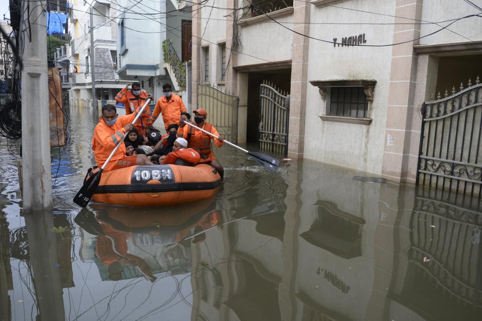 National Disaster Response Force (NDRF) personnel evacuate local residents in a boat along a flooded street following heavy rains in Hyderabad on October 15, 2020. (Photo by NOAH SEELAM / AFP) (Photo by NOAH SEELAM/AFP via Getty Images)