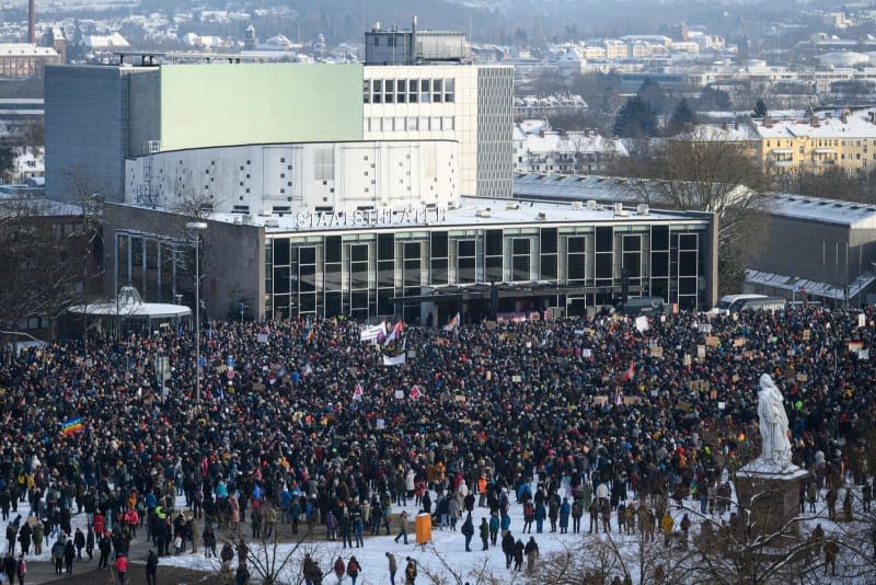 People stand in front of the State Theater on Friedrichsplatz during a demonstration against the AfD and right-wing extremism in Hesse. Swen Pförtner/dpa