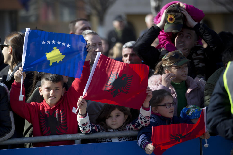 Kosovars waving national flags pose for a photo, during celebrations to mark the 11th anniversary of independence, in Pristina, Sunday, Feb. 17, 2019. Kosovo has celebrated its 11th anniversary of independence with a military a parade but still in tense relations with its former foe Serbia. (AP Photo/Visar Kryeziu)(AP Photo/Visar Kryeziu)