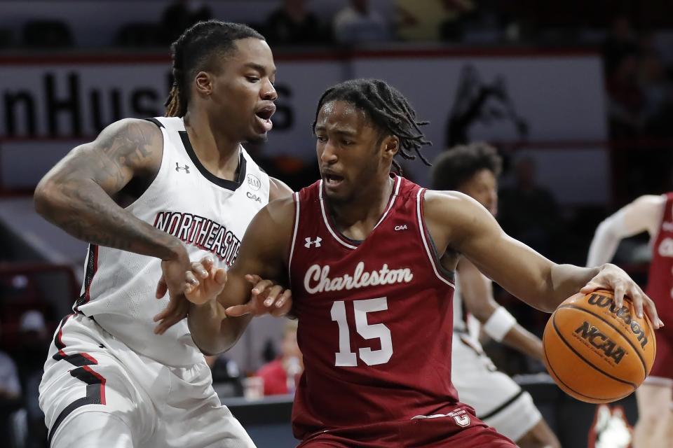 Charleston's Pat Robinson III (15) drives against Northeastern's Jahmyl Telfort during the first half of an NCAA college basketball game, Saturday, Jan. 21, 2023, in Boston. (AP Photo/Michael Dwyer)