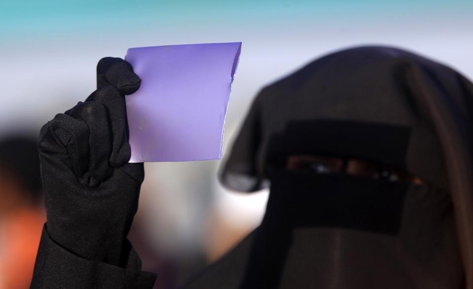 A veiled woman observes a solar eclipse during an event organized by the Sudanese Society for Astronomy and Space Science on the banks of the Nile river in Khartoum