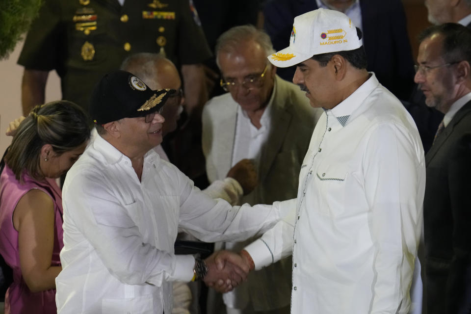 El presidente de Venezuela, Nicolás Maduro, y el mandatario colombiano, Gustavo Petro, a la izquierda, estrechan manos tras su encuentro en el palacio presidencial de Miraflores, in Caracas, Venezuela, el martes 9 de abril de 2024. (AP Foto/Ariana Cubillos)