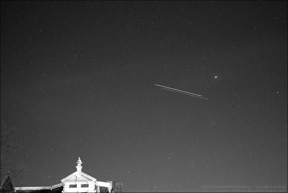 NASA's space shuttle Discovery and the International Space Station are seen in this time-lapse image as they fly over Leiden, The Netherlands, just before the two spacecraft docked on March 17, 2009 during the STS-119 mission. The shuttle is th