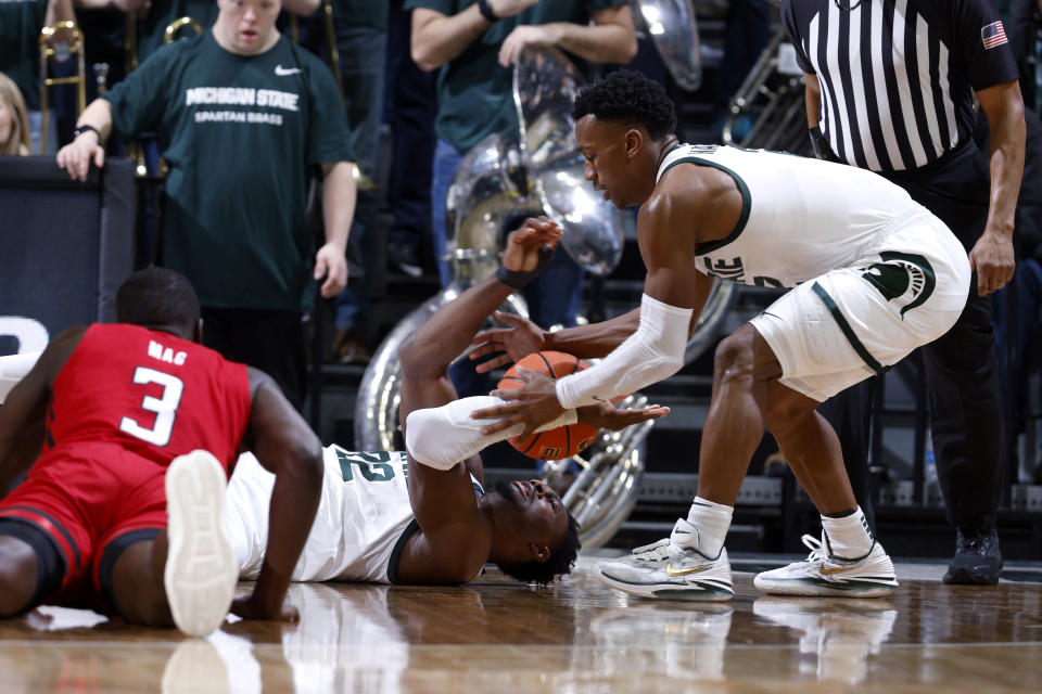 Michigan State center Mady Sissoko, center, passes the ball to Michigan State guard Tyson Walker, right, as Rutgers forward Mawot Mag (3) watches during the first half of an NCAA college basketball game, Sunday, Jan. 14, 2024, in East Lansing, Mich. (AP Photo/Al Goldis)