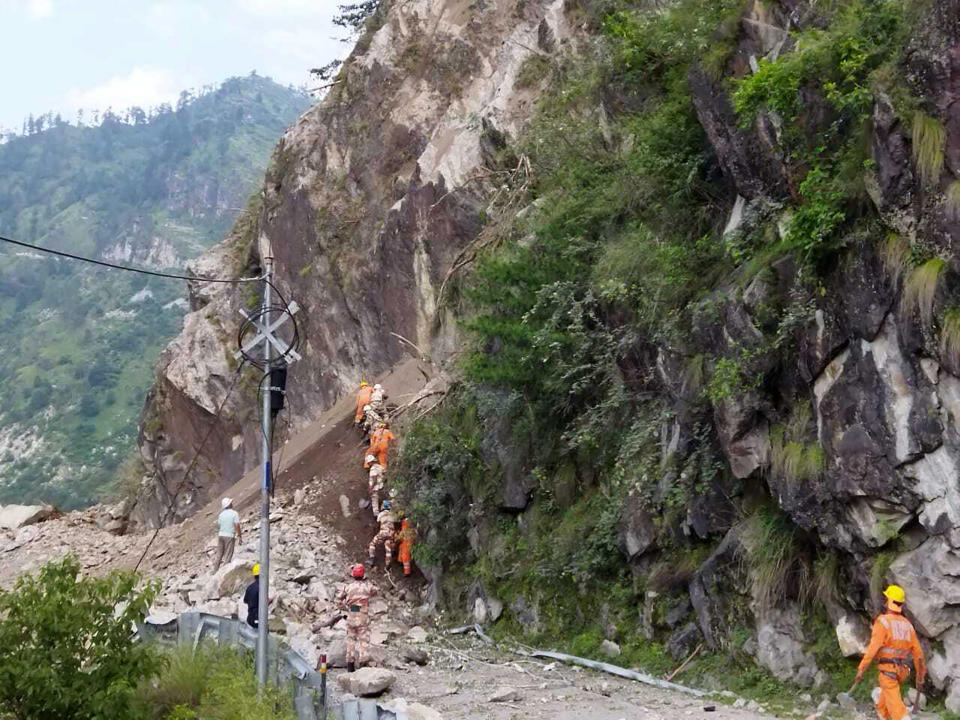 This photograph provided by India's National Disaster Response Force (NDRF) shows NDRF soldiers working on a rescue operation at the site of a landslide in Kinnaur district in the northern Indian state of Himachal Pradesh, Wednesday, Aug. 11, 2021. A landslide struck several vehicles traveling on a highway in the hills of northern India on Wednesday, trapping as many as 50 people, officials said. (National Disaster Response Force via AP)