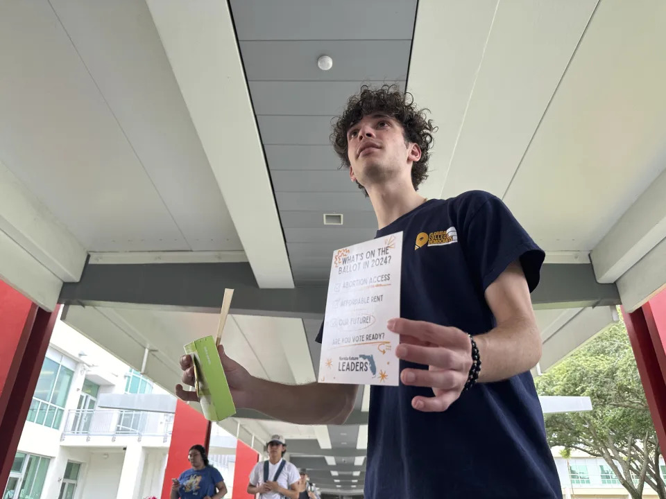 Jayden D'Onofrio passes out Plan B, condoms and rolling papers to educate young voters at Florida Atlantic University on Thursday, April 11 in Boca Raton, Fla. Abortion and marijuana will be on Florida's November ballot, and these issues are critical issues for young voters. (AP Photo/Cody Jackson)