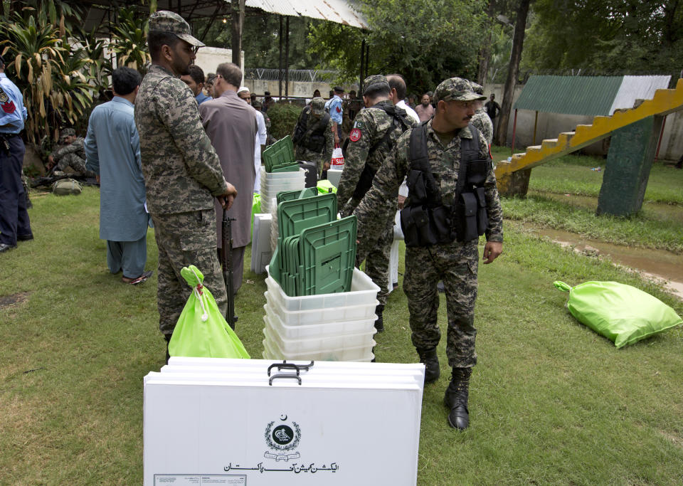 Pakistani soldiers guard a polling material assigned to staff at a distribution center in Islamabad, Pakistan, Tuesday, July 24, 2018. As Pakistan prepares to make history Wednesday by electing a third straight civilian government, rights activists, analysts and candidates say the campaign has been among its dirtiest ever, imperiling the country's wobbly transition to democratic rule. (AP Photo/B.K. Bangash)