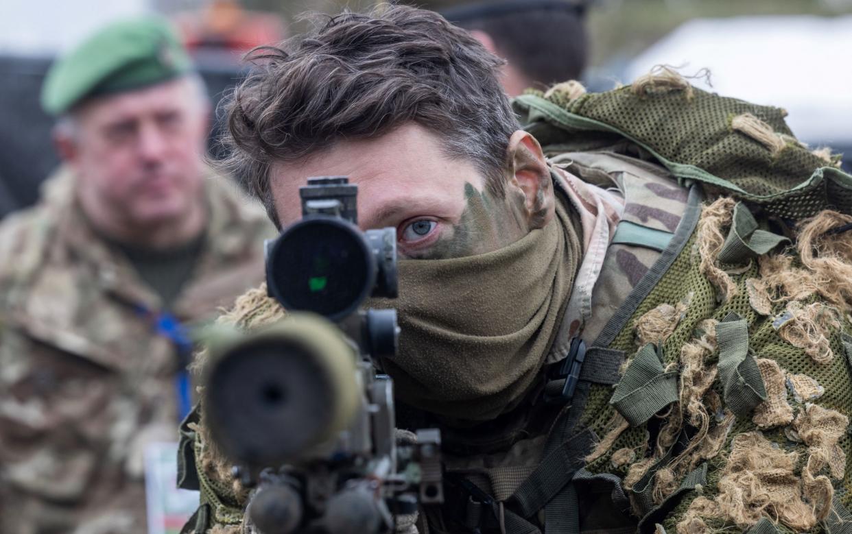 A British soldier looks into a telescopic sight on a sniper rifle during a Nato exercise in Poland in March