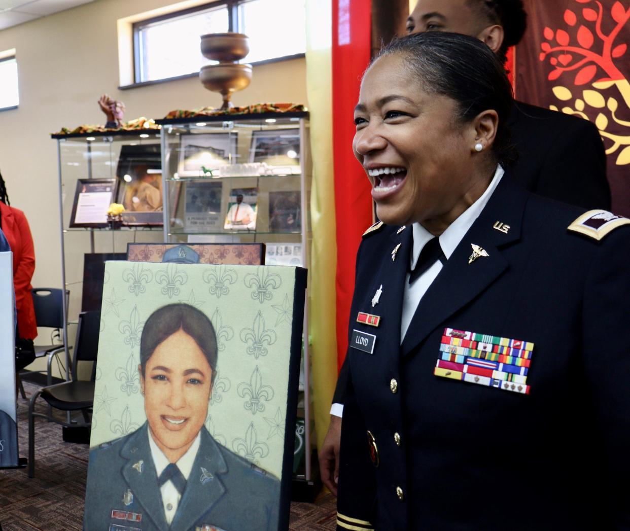 Col. Katrina Lloyd, a Peabody Magnet High School graduate, stands beside her portrait Saturday at the grand opening of the Central Louisiana African American Culture & Heritage Center at the Martin Luther King Jr. branch of the Rapides Parish Library.